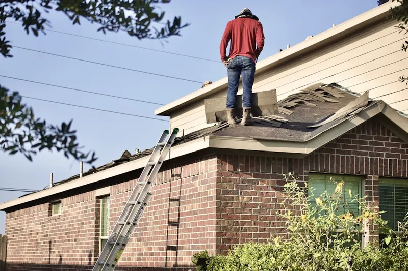 Professional roofer working on a residential roof in Patuisset